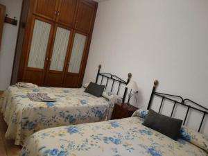 纳赫拉El Herrador的一间卧室配有两张带蓝白色床单的床