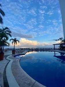 巴亚尔塔港科斯塔苏尔Spa及度假酒店的棕榈树海滩旁的大型游泳池