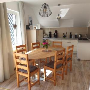 耶弗尔Friesenauster - große Ferienwohnung für bis zu 6 Personen的厨房以及带木桌和椅子的用餐室。