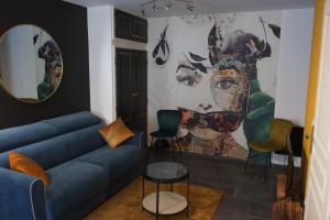 多勒Duplex charmant idéalement situé的客厅配有沙发和墙上的绘画