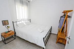 纳哈里亚פנינה באכזיב- מול הים- achzivacation的卧室配有白色的床和木梯