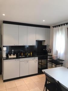博斯克古林Appartamento da 2 locali a Bosco Gurin的厨房配有白色橱柜和黑色台面