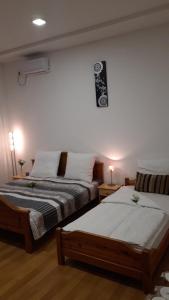 图兹拉Apartment and rooms"Tabašnice"Tuzla centar的卧室配有两张床,墙上有标志
