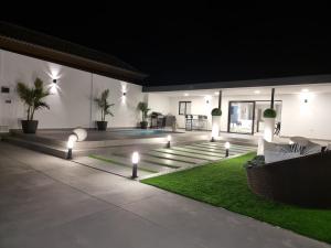 阿罗纳ViLLA DREAMS JF的一个带灯光和游泳池的庭院