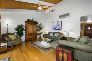 科纳科纳海岸度假村金奥浩花园8204公寓的客厅配有家具和吊扇