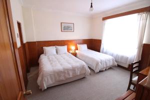 蓬塔阿雷纳斯CHALET CHAPITAL Punta Arenas的酒店客房设有两张床和窗户。