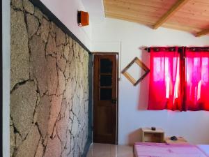 波多诺伏Pedra de Rala的一间设有红色窗帘和石墙的房间