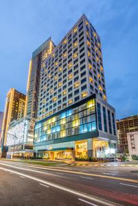 新山Fives Hotel Johor Bahru City Centre的城市街道上一座高大的建筑,有很多窗户