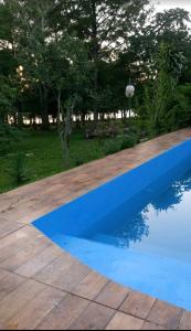 Puerto LibertadEl Amanecer Don Zenon Lago Urugua-i的一座绿树成荫的庭院内的蓝色游泳池