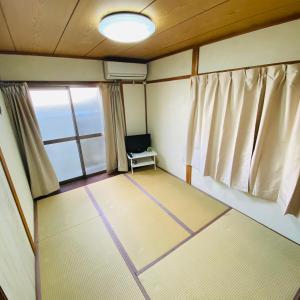 田边市熊野宾馆的一间空房间,配有椅子和窗户