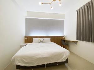 台东困家南岛馆的卧室配有一张白色大床
