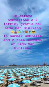 里米尼LA CASA DI CLARA ombrellone con 2 lettini al Lido San Giuliano gratis e parcheggio privato gratis的海滩上一大群遮阳伞