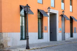 拉·格兰哈·圣·伊尔德Hotel AR Isabel de Farnesio的橘色建筑前的街道灯