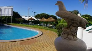 阿尔布费拉Debimar Apartamentos的一座游泳池旁的鸡雕像
