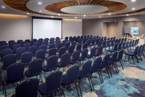 奥拉涅斯塔德Hyatt Place Aruba Airport的一间会议室,配有蓝色椅子和投影屏幕