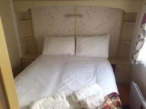 乌伊格Skye Holiday Chalets C1的卧室内的一张带白色床单和枕头的床