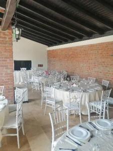 ZăbraniPENSIUNEA ALEXANDRA的宴会厅配有白色的桌子和白色的椅子