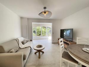 昂蒂布Superbe appartement au cœur du Cap d'Antibes的客厅配有沙发和桌子