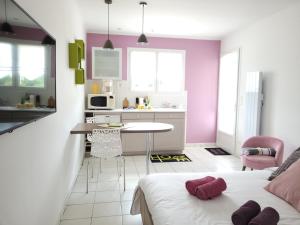 OrdonnacCoquet studio en Médoc, Jacuzzi et climatisation的一间设有一张床的客房和一间带紫色墙壁的厨房