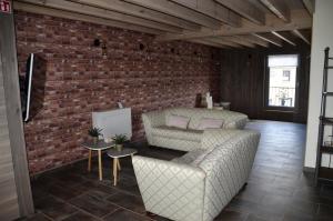 塞尔方丹Gîtes Paille-Foin的客厅设有两张沙发和砖墙