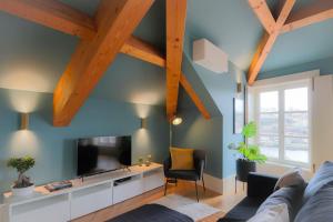 波尔图HM - Infante Riverside Apartment R的客厅设有蓝色的墙壁和木梁。