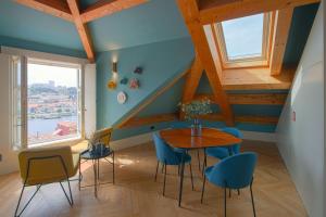 波尔图HM - Infante Riverside Apartment R的一间带桌子和蓝色椅子的用餐室