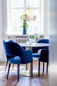 Augustenborg'Gem Suites Luxury Holiday Apartments的一间配备有蓝色椅子和桌子的用餐室