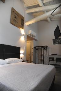 圣塞孔多-帕尔门塞TLcafè Hospitality (presso Torrefazione Lady Cafè srl)的卧室配有白色的床和墙上的电视。