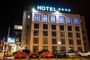 BuzăuHotel Avenue - Avenue Hotels的一家晚上停在酒店前面的汽车酒店