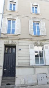 昂热Les Suites Angevines的一座建筑,设有黑色的门和三扇窗户