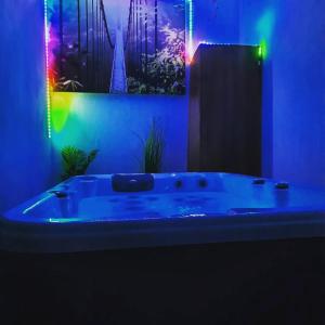 Saint-Mitre-les-RempartsMaison avec jacuzzi的蓝色的浴室设有浴缸,内有灯光