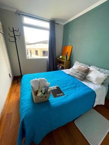 危地马拉Habitación cómoda y céntrica的一间卧室配有一张带蓝色毯子的床和窗户。
