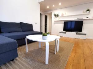 托莱多Apartamento Vicario Toledo的客厅配有蓝色的沙发和白色的桌子