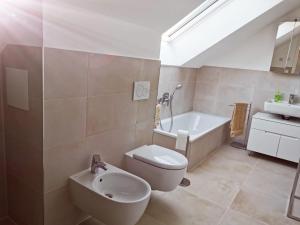 塞勒姆Schlossseeapartment的浴室配有卫生间、盥洗盆和浴缸。