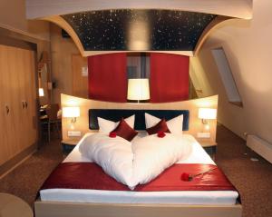 旧天鹅堡Hotel Villa Ludwig的一间卧室配有一张带红色和白色枕头的大床