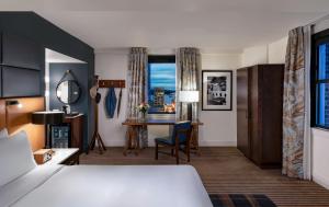 西雅图西奥多酒店 - 起源酒店的配有一张床和一张书桌的酒店客房