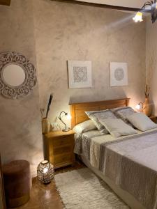CastellnovoCasa Rural Valle del Palancia的一间卧室配有一张带镜子和凳子的床