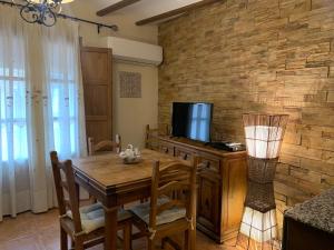 CastellnovoCasa Rural Valle del Palancia的一间带木桌和电视的用餐室