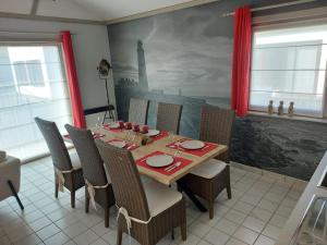米德尔克尔克The Lighthouse的用餐室配有桌椅和绘画作品