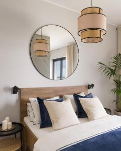 济夫努夫Apartament MorSky Gardenia Dziwnów的卧室配有大镜子,位于床上方,配有蓝色枕头