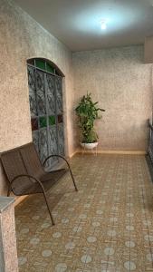 迪维诺波利斯Hostel Assis Divinópolis的一间房间,配有椅子和盆栽植物