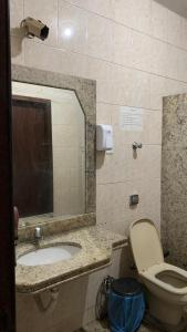 迪维诺波利斯Hostel Assis Divinópolis的一间带水槽、卫生间和镜子的浴室