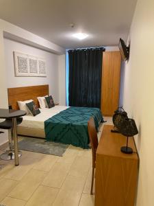 丰沙尔埃斯梅拉达假日公寓的一间卧室配有一张床、一张桌子和一张书桌