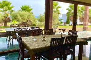 阿德拉Alcazaba Hills的一间带桌椅的用餐室和大窗户