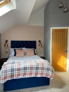 埃文河畔斯特拉特福Stratford House的一间卧室配有蓝色的床和粉红色枕头