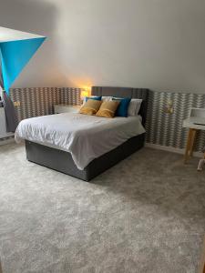 埃文河畔斯特拉特福Stratford House的一间卧室配有蓝色和黄色枕头的床