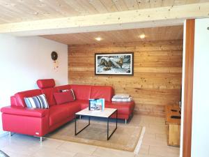利德阿尔卑斯Chalet Enzian的客厅配有红色的沙发和桌子