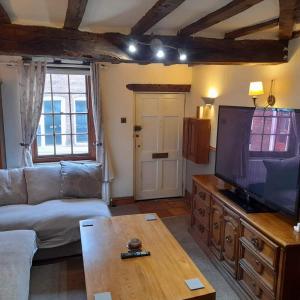 布由德利Cosy Georgian Cottage in the Heart of Bewdley, Worcestershire的带沙发和大电视的客厅