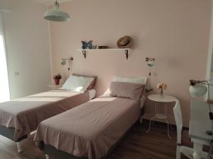 科莫LORA GIUSTA GUEST HOUSE的小型客房配有两张床和一张桌子。