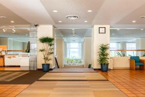 鸟羽鸟羽维斯特里安生活俱乐部酒店的办公室大厅,地板上种植盆栽植物